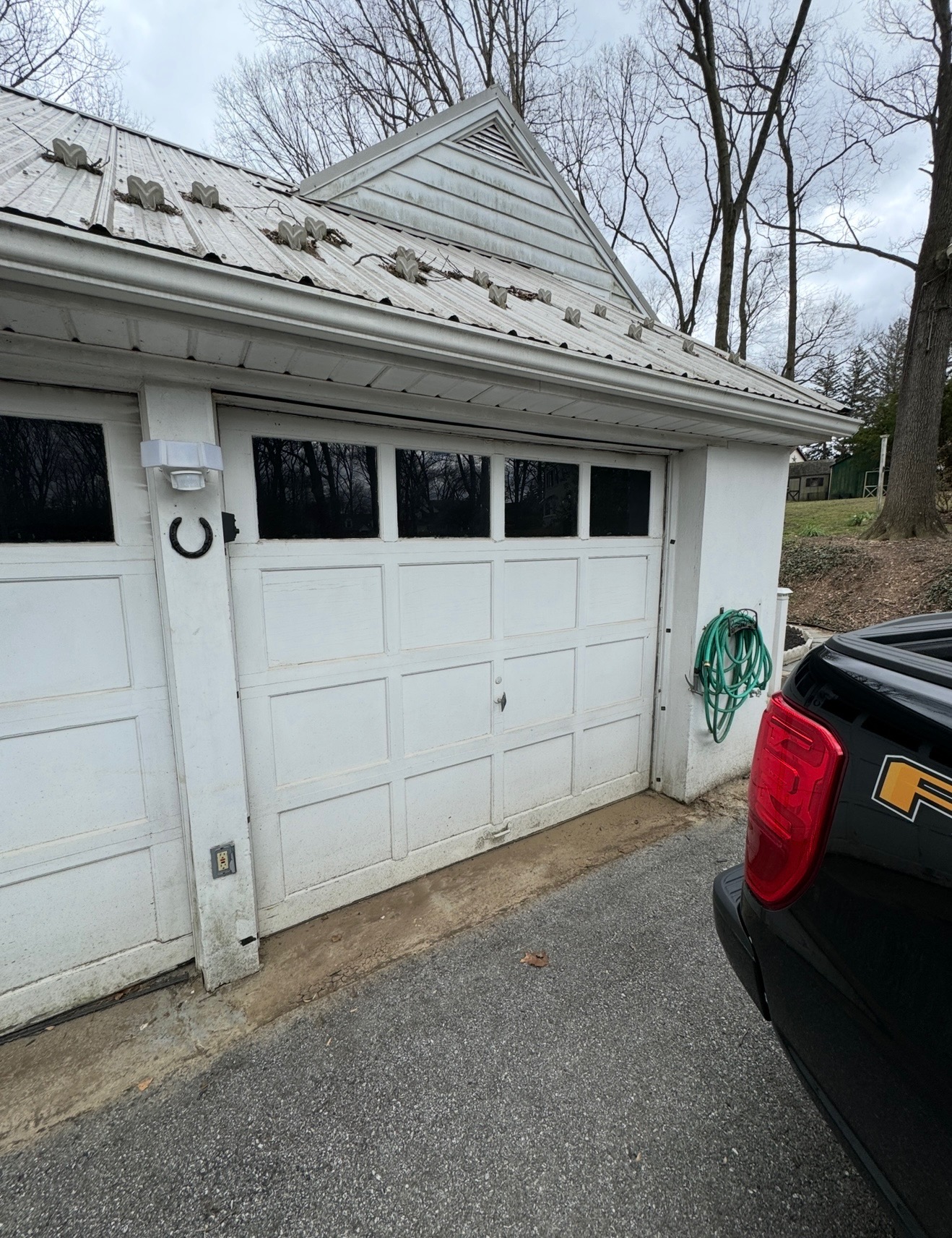 Before: Old plain white raised-panel garage doors on detached two-car garage